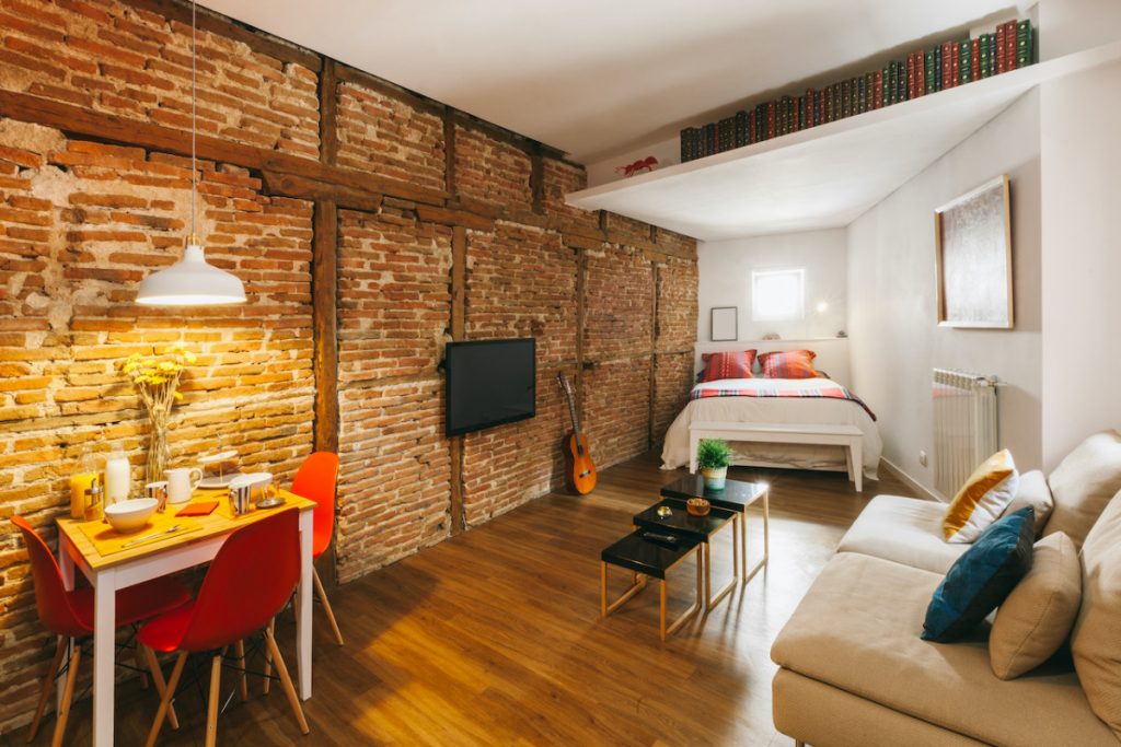 Apartamento com decoração rústica e parede de tijolos 