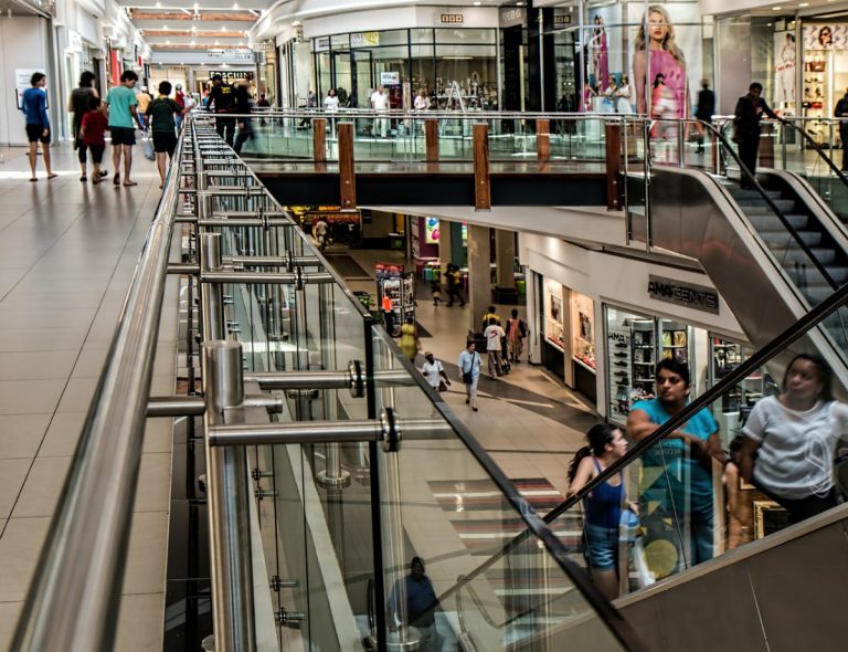 Pessoas em escada rolante do shopping durante compras